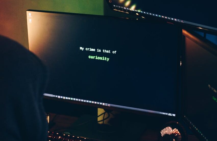 unrecognizable male cyber spy hacking computer system in darkness