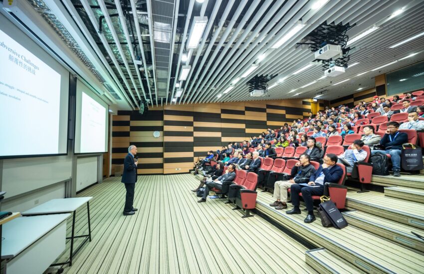 man standing in front of people sitting on red chairs